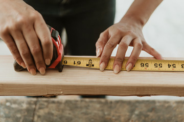 Professional carpenter measuring wood