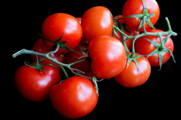 Bunch of tomatoes on dark slate background. Healthy food concept. Close up. Macro