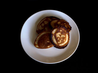 Crepes or blini or pancakes on white plate on black background. breakfast morning food