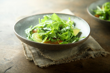 Healthy arugula salad with tomato and avocado