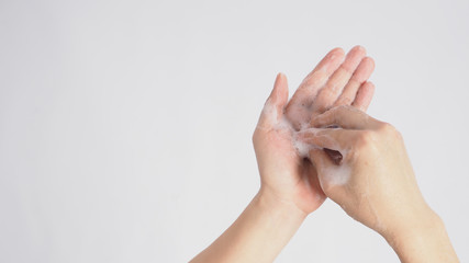 Male model is rub fingertips of one hand on the other plam foaming hand soap on white background.