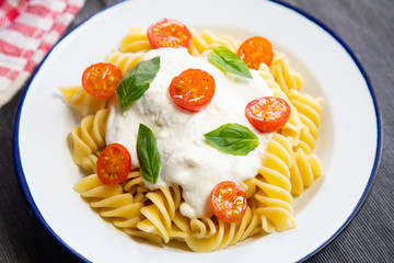 Fusilli with mozzarella sauce and cherry tomatoes