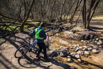 Naklejka premium With a bike across the creek