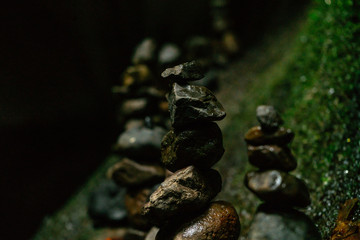 Balancing stones tower on mossy stone background