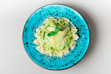 Pasta in original plate with parmesan and basil