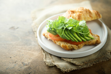 Croissant sandwich with tomato and avocado