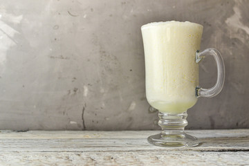 Spoiled milk. Kefir. Ayran in a glass Glass transparent glass. Free space for text. Light gray...
