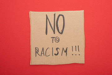 top view of carton placard with no to racism lettering on red background