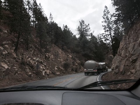 Truck On Road By Rocks Seen From Car Windshield