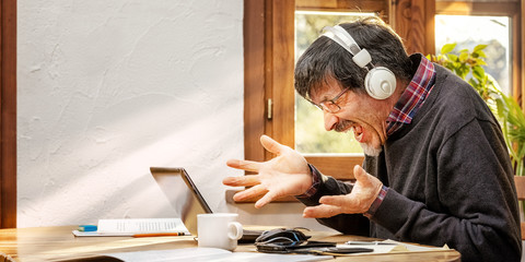 Fototapeta na wymiar Man working from his improvised home office is upset