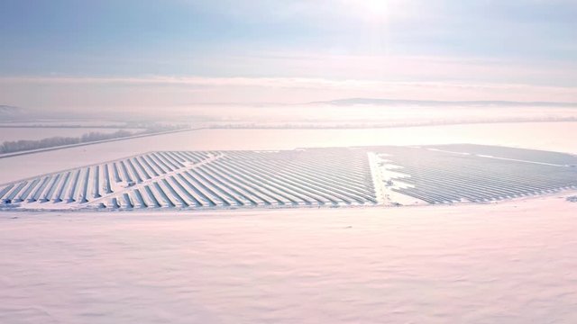 Aerial perspective Solar panel farm Green Energy at winter snow sunny day drone shot of Ecology Power Conservation