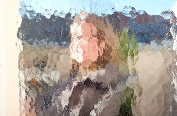 Face of a woman distorted by a window