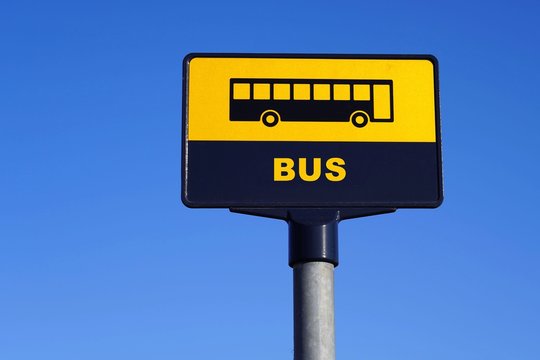 Bus stop sign on the blue sky .