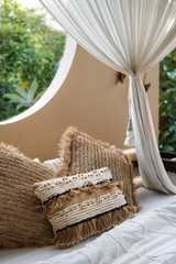 Open space bedroom with pillows on bedsheets and baldachin over bed © brizmaker