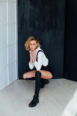 Portrait of a beautiful fashionable blonde woman in black shorts and white shirt © dmitriisimakov