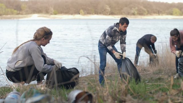 People collecting garbage near the lake