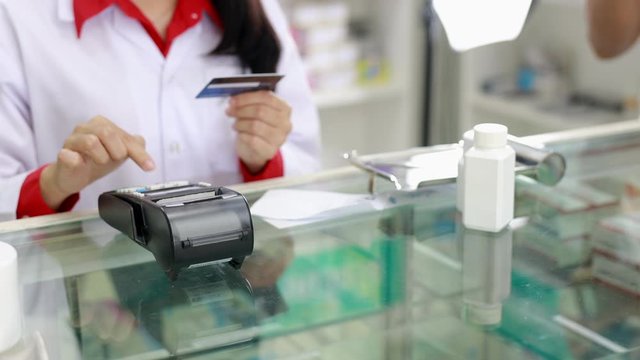 Pharmacist accept payment by credit card from customers in pharmacy Thailand 4k video 