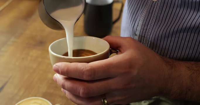 Close-up of a vintage barista making an artistic composition of a heart with fresh milk to make a cappuccino using an Italian espresso.
Italian concept, passion for work.