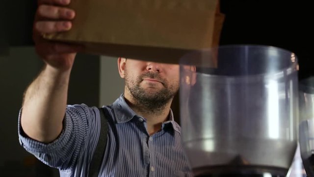 Close-up of a vintage barista man doing coffee beans in a coffee grinder. SLOMO-version
