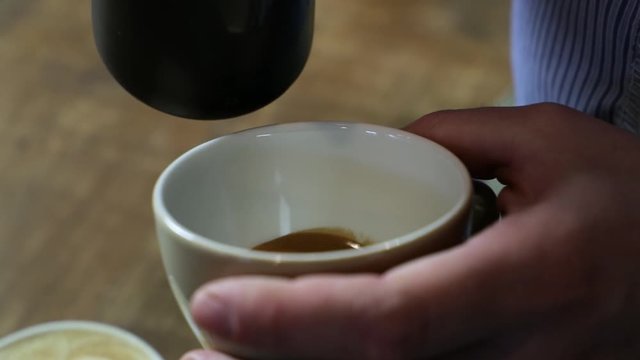 Close-up of a vintage barista making an artistic composition with fresh milk to make a cappuccino using an Italian espresso.
Italian concept, passion for work, breakfast and love for coffee. SLOMO
