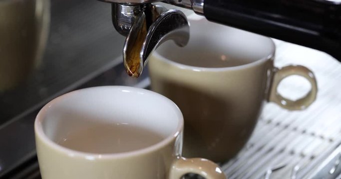 Close-up of vintage barista making two espresso's or Americano's on an authentic Italian coffee machine.