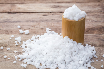 Sea salt in wooden spoon on a wood table. spa salt