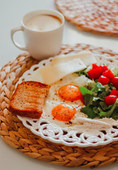 breakfast with fried eggs, fresh vegetables, cheese,bread and coffee