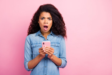 Portrait of amazed social media lover addicted afro american girl blogger use smart phone get...