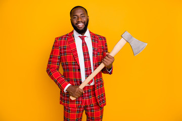 Photo of attractive funky dark skin guy good mood hold steel ax halloween students party wear checkered red costume blazer shirt tie pants isolated yellow color background