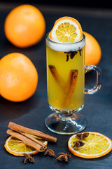 traditional grog drink with cinnamon sticks and orange on a dark background