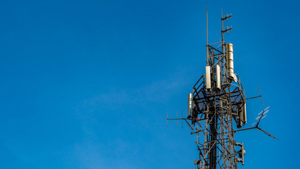 Mid shot of Communications tower hosting various antennas and dishes
