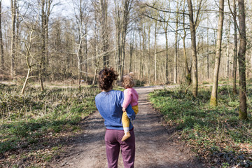 petite fille dans les bras de sa maman en extèrieur