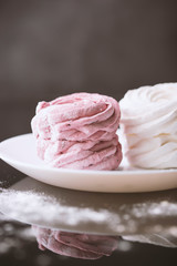 White and pink marshmallows shot on a dark background