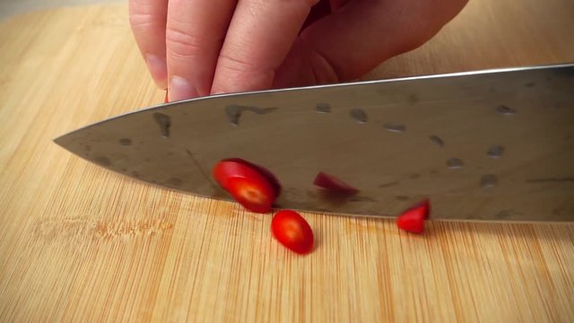 The cook cuts the capi pepper with a knife. Slow motion.