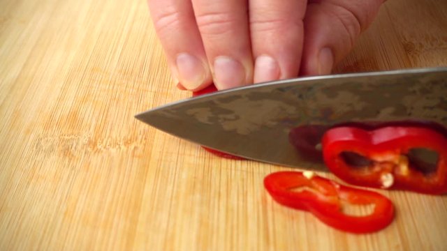The cook cuts the capi pepper with a knife. Slow motion.