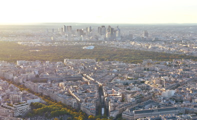 Parisian cityscape at sunset from elevated viewpoint. View of La Defense business district and Bois de Boulogne. Paris, France.