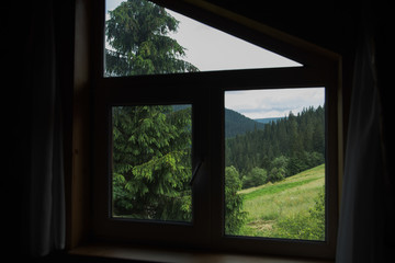 Fototapeta na wymiar Amazing peaceful green landscape seen through closed rural window.