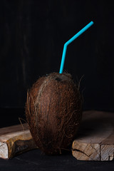 Dark coconut with straw on a ninth background