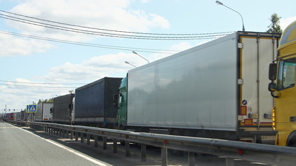 Long queue traffic congestion of many heavy trucks with semi-trailers to the control point in...