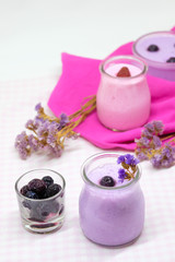 Obraz na płótnie Canvas Blueberry and strawberry jelly mousse in glass cups with pink and purple dry flowers