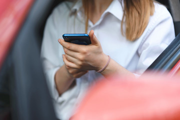 woman holding smartphone in car
