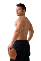 Muscular american football player standing with ball in hand, seen from the back, isolated
