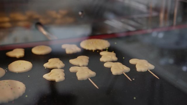 Appetizing shortbread cookies are cooked in the oven, holiday gingerbreads in the form of rabbits, chickens and eggs, Easter, time lapse