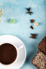 A cup of tea with anise flowers and cinnamon on blue background