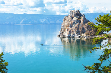 Magnificent summer landscape with Baikal Lake on a sunny day. Tourists travel in a rubber boat...
