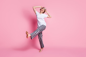 Full length photo of funny lady raise leg good mood slumber girls night party wear sleep mask white t-shirt checkered pajama pants barefoot isolated pink color background