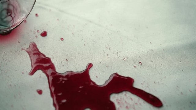 Spilled red wine on the table. Spilled red wine on a white cloth.