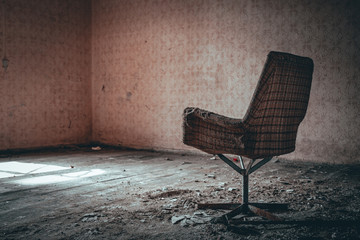 stary zniszczony fotel w opuszczonym budynku	
