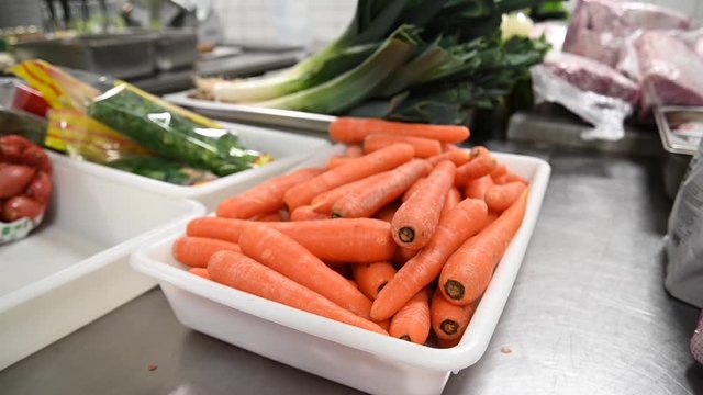 Bac de carottes dans une cuisine professionnelle
