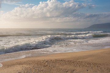 Sea wave and pebble on the sand beach with sunlight. Natural composition